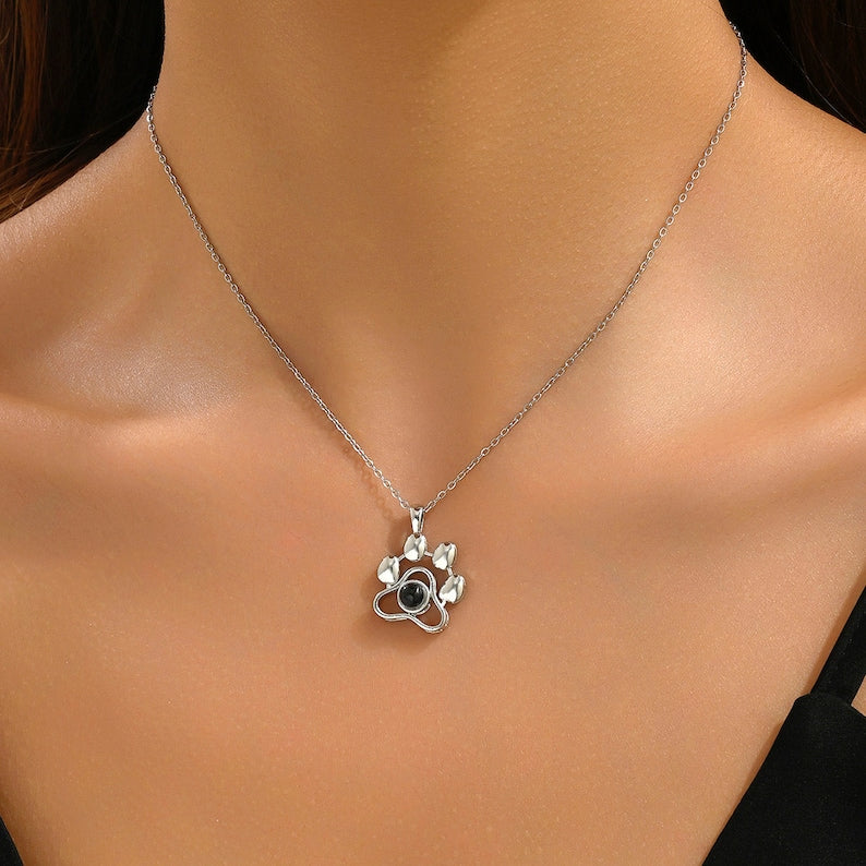 Woman wearing a silver paw pendant necklace with picture inside on a fine chain